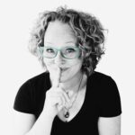 Black and white portrait photo of Anne Bovelett, a woman with short curly hair and glasses.